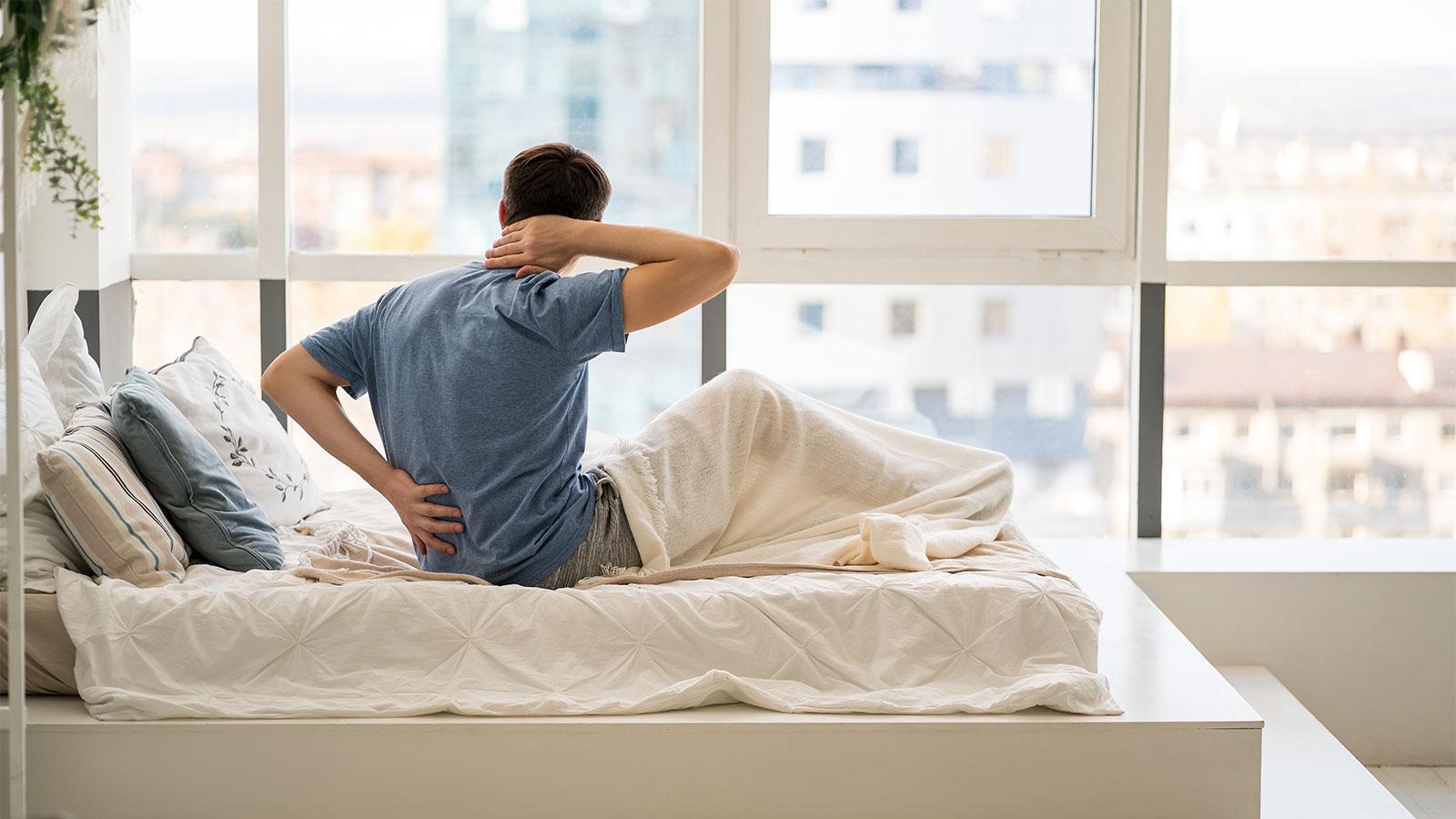 腰と首を押さえる人物