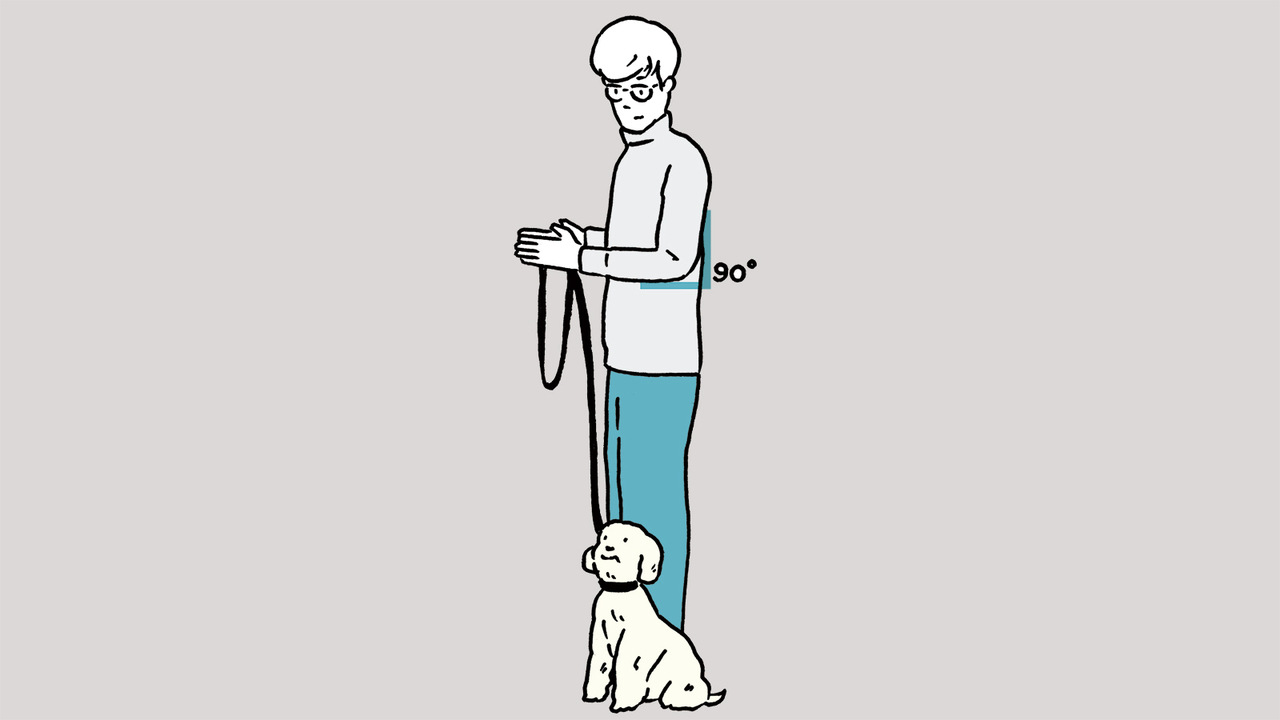 犬を左側のヒールポジションに坐らせる（立たせてもOK）。犬が正面または上を向いた状態で左肘を90度曲げる。