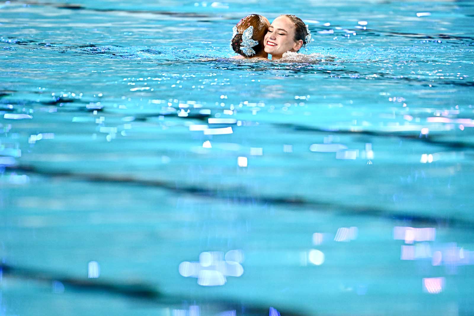 水中で抱き合う女子デュエットの選手たち。