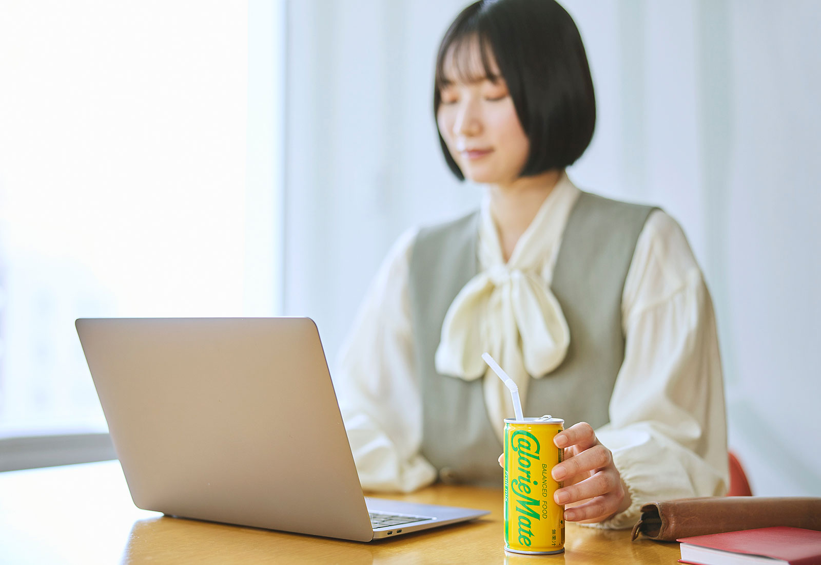 カロリーメイトリキッドを片手に飲む女性