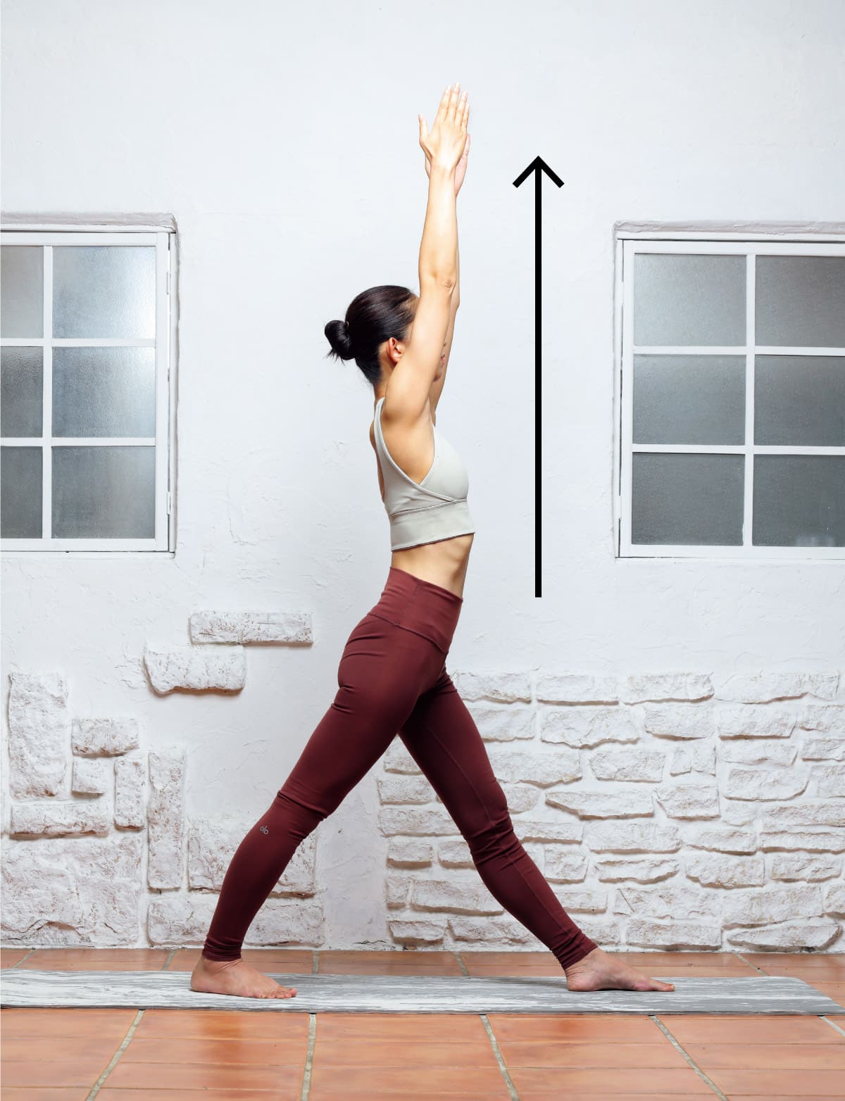 両手を合わせ頭上に上げる女性