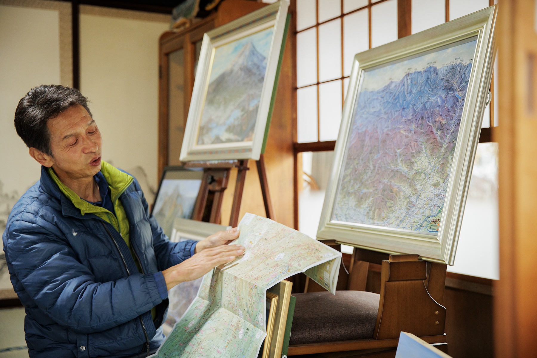 自身が監修・執筆した地図を広げる温井さん