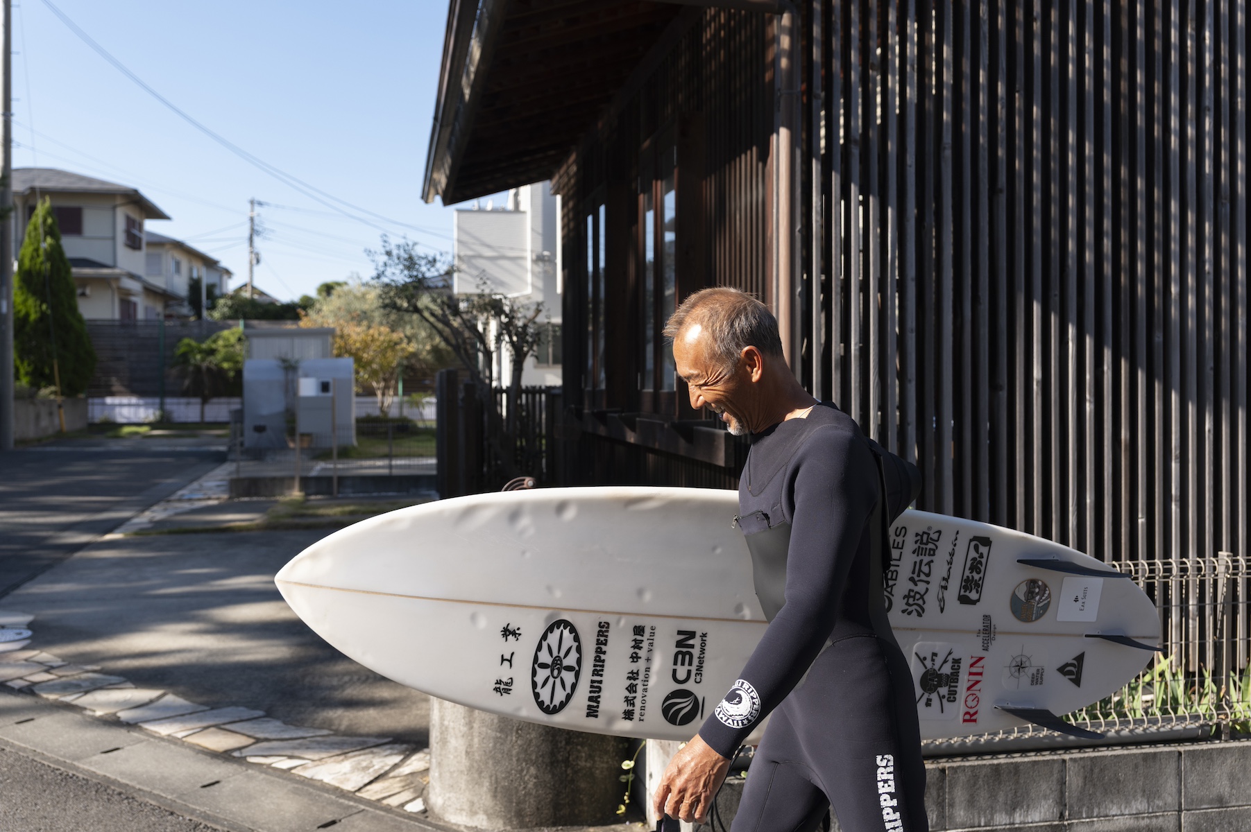 サーフボードを手に、海まで歩く勝倉直道さん