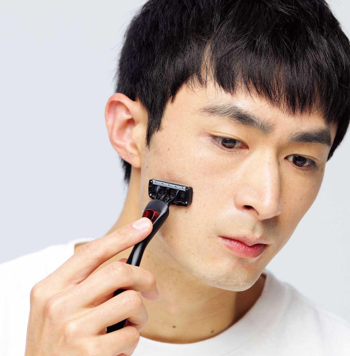 男性がカミソリで髭を剃っている様子