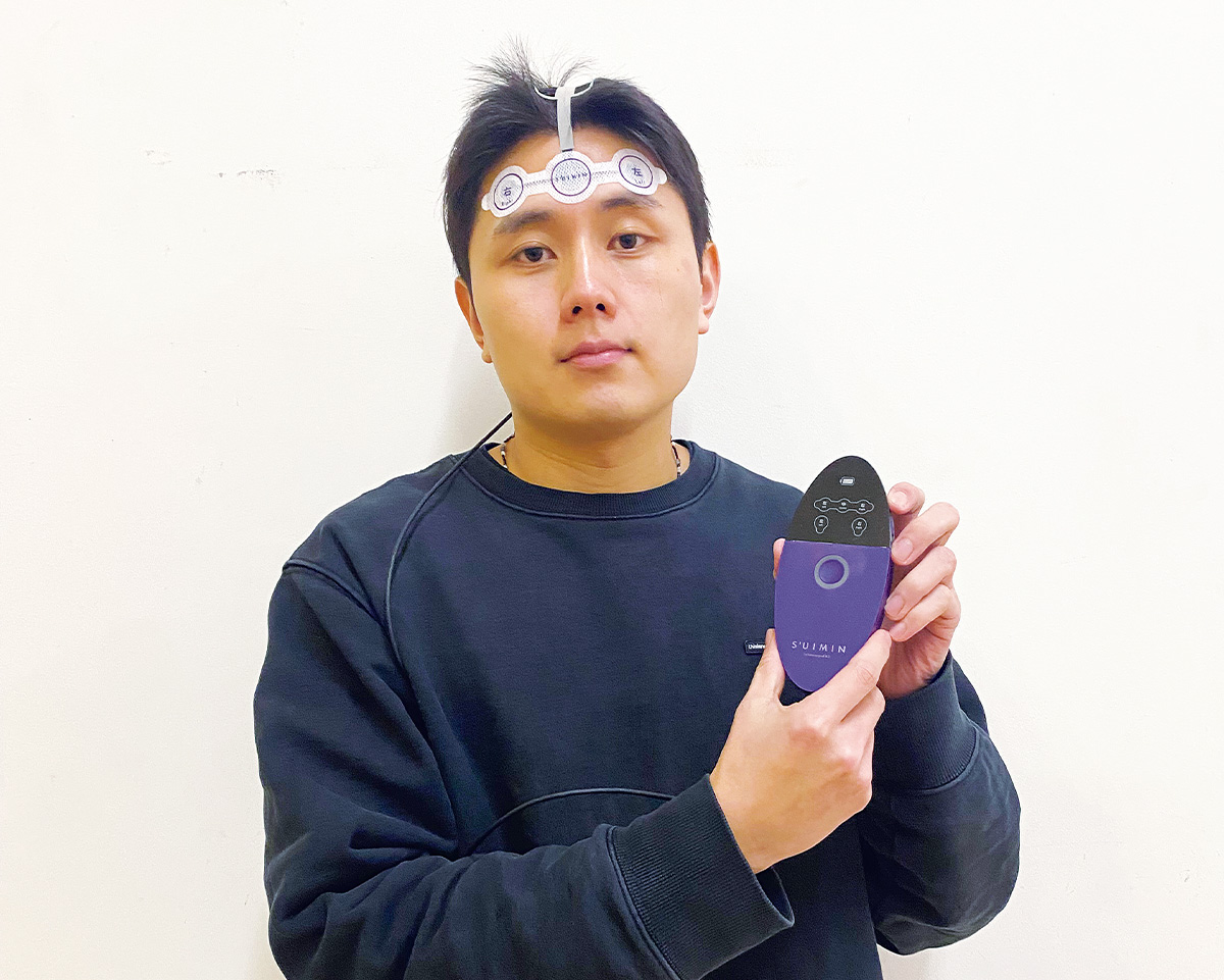 頭に実験装置をつけている学生