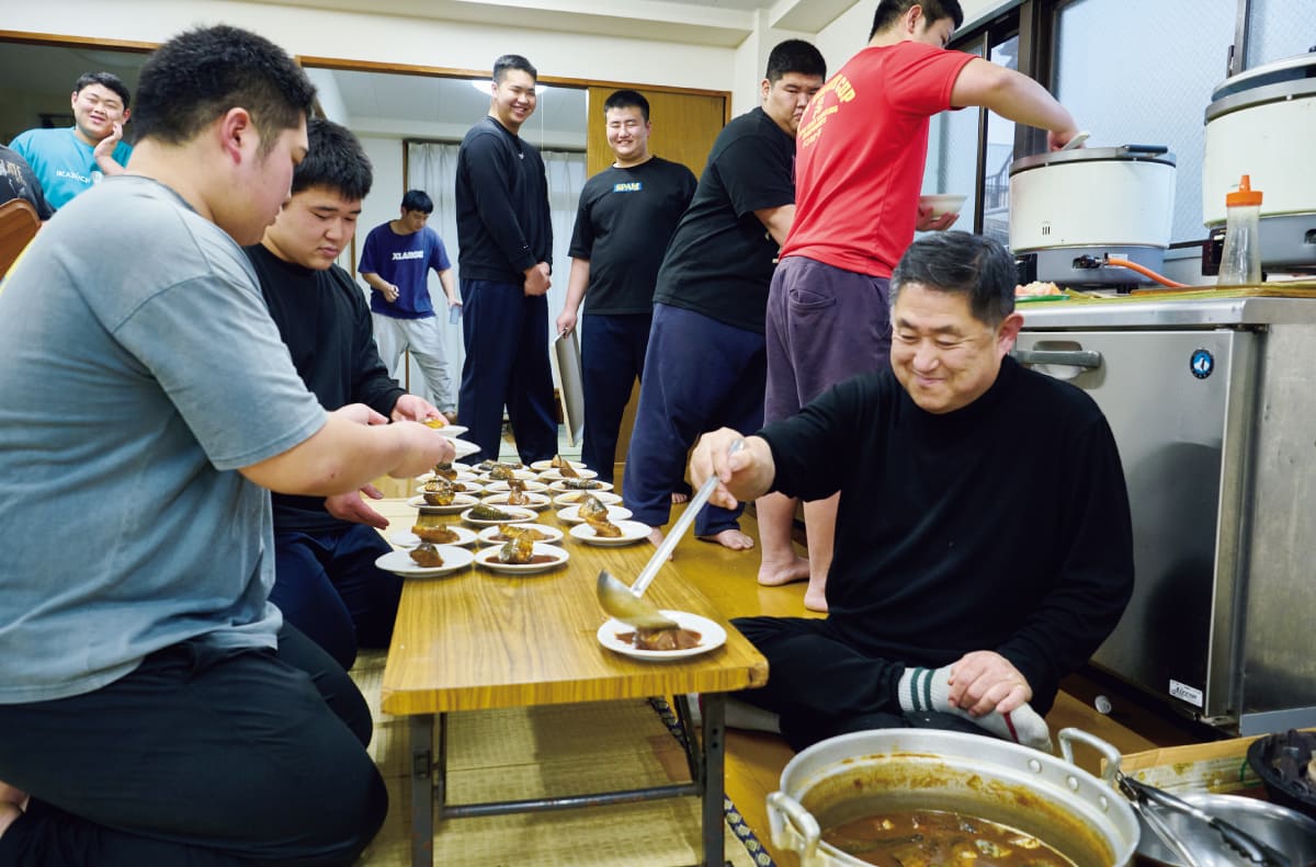 料理を盛り付ける山田監督と生徒たち