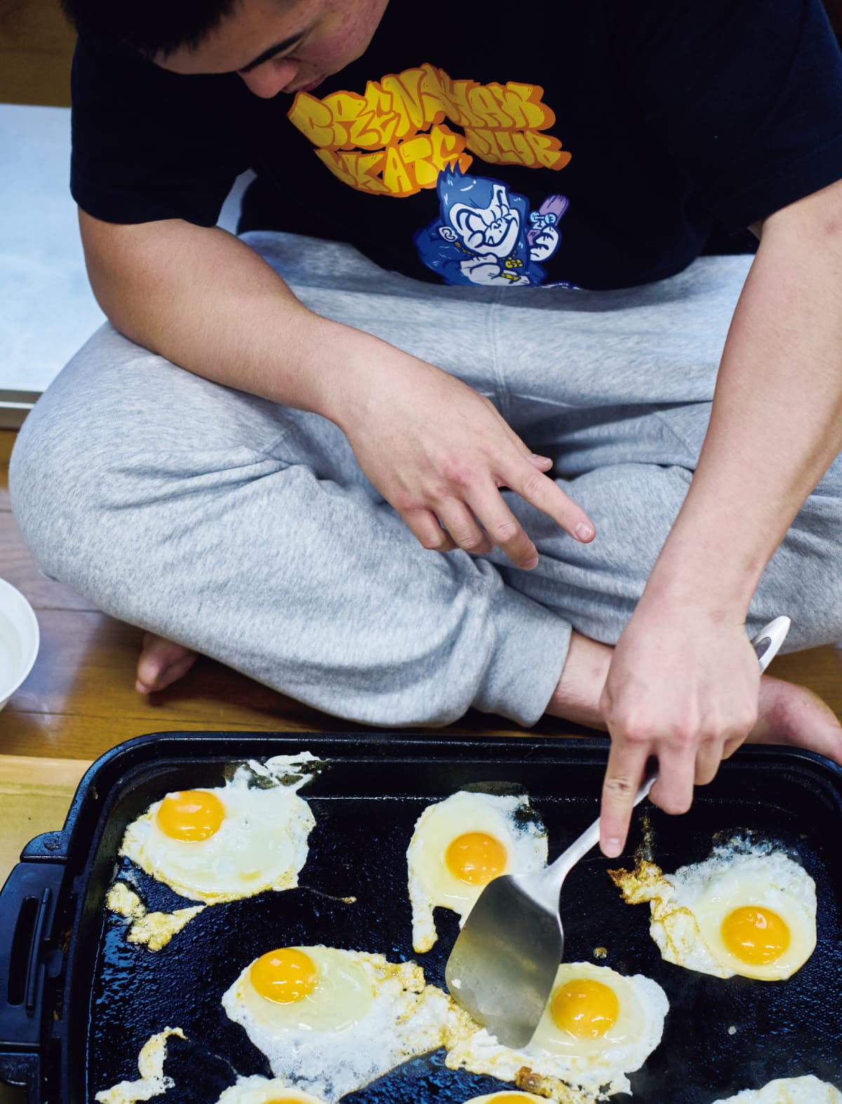 目玉焼きをきれいに配列して焼いている生徒の姿
