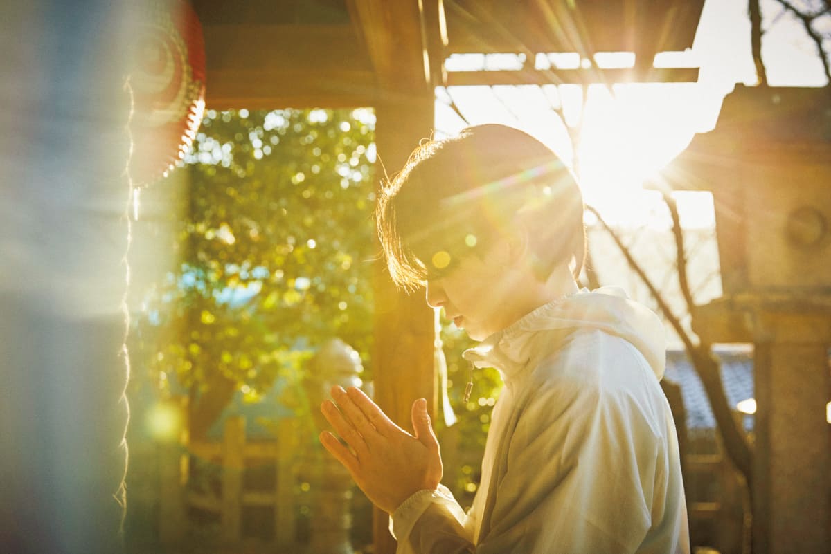 ご来光を背に神社で拝んでいる様子