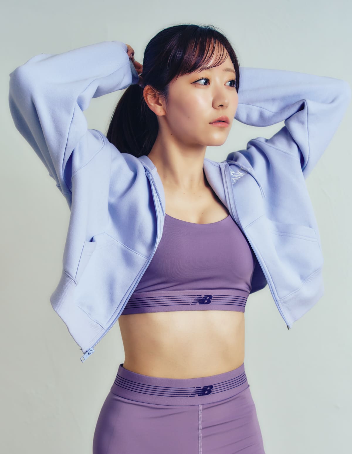真中まなが両手をあげ、手を頭につけている様子