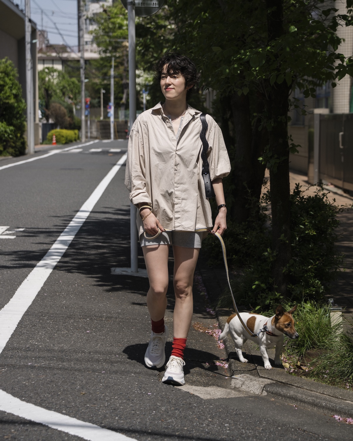 〈HOKA〉の《Mach 7》アラバスター／ソアリング ブルーを履いて犬と歩く道木マヤさん