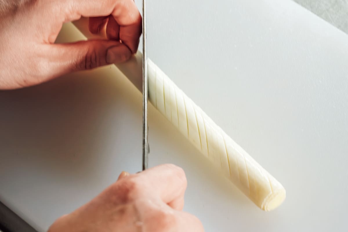 鶏納豆炒めのせ冷やしうどん。長ネギを斜めに切り目を入れている様子
