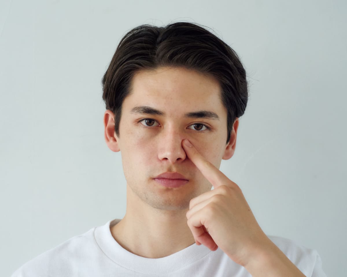 人差し指を使い鼻のラインの筋肉に沿いながら目頭にかけて刺激している様子