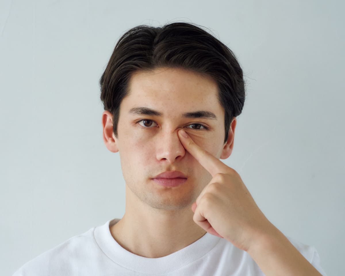 人差し指を使い鼻のラインの筋肉に沿いながら目頭にかけて刺激している様子
