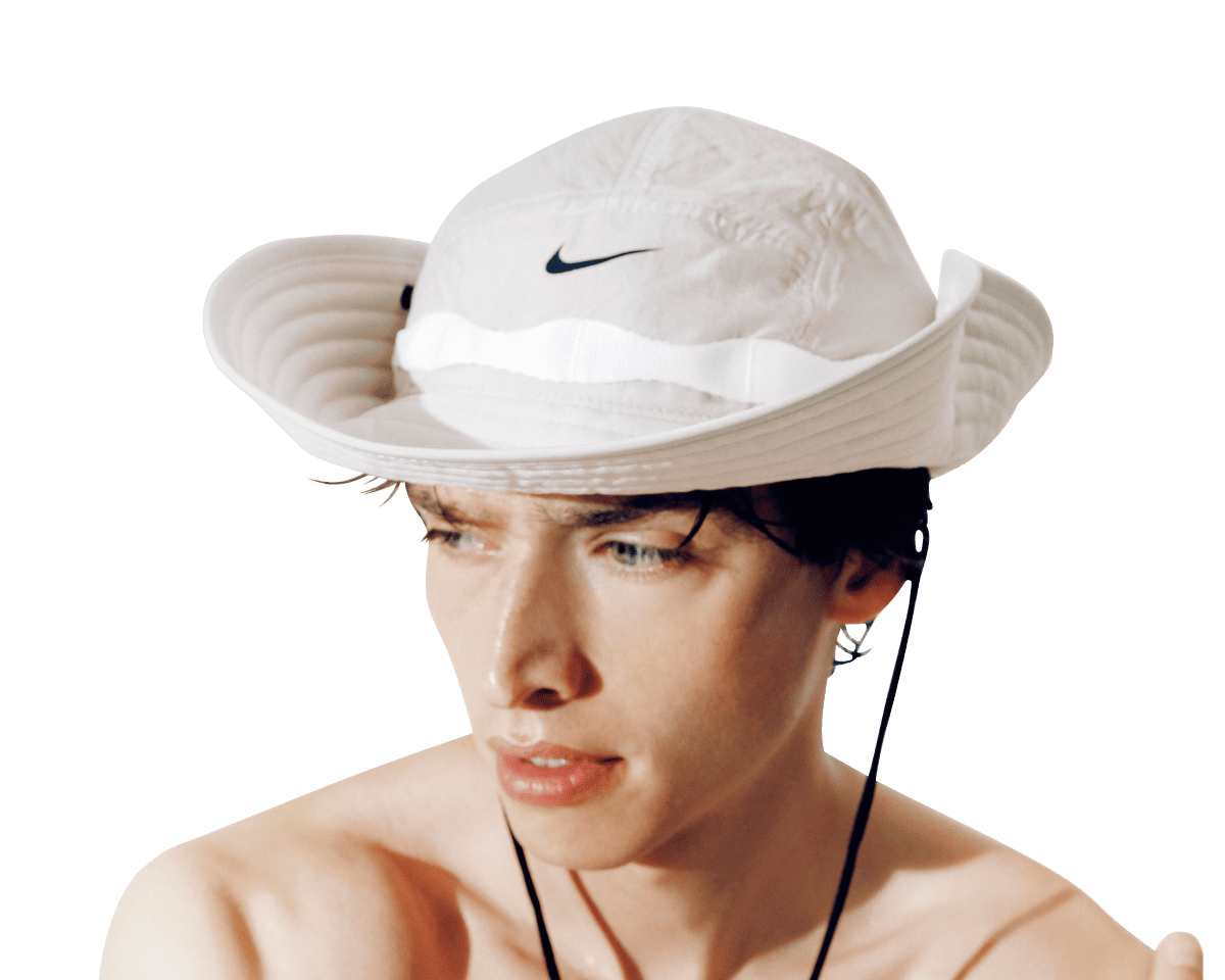 〈NIKE〉のバケットハットをうカウボーイ風にかぶっている様子