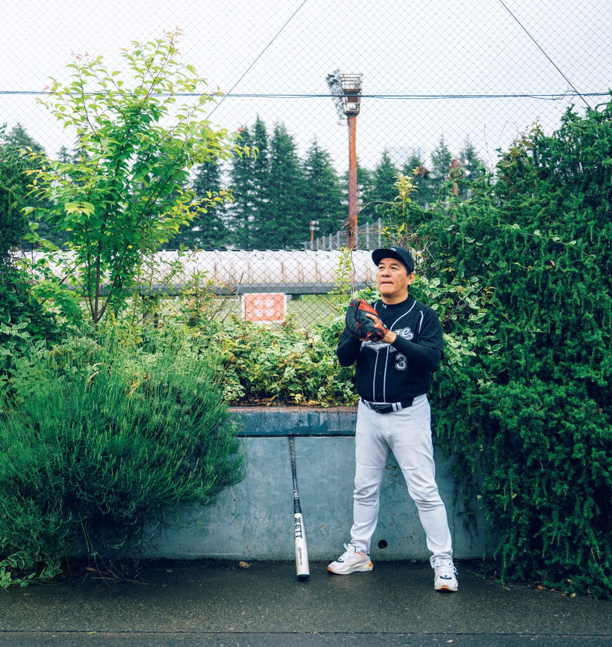 ピエール瀧さんが正面を向きユニフォーム姿でグランド付近に立っている様子