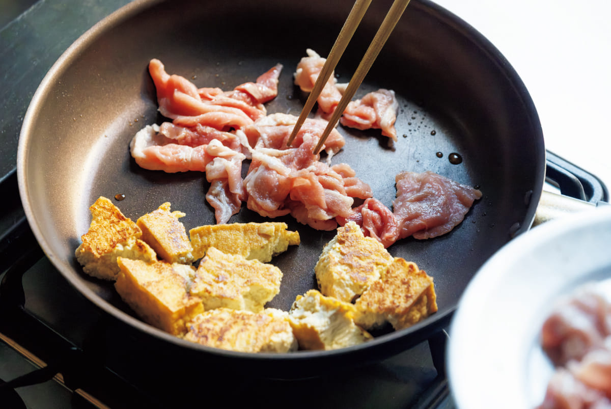 フライパンで豚肉と厚揚げを炒める様子