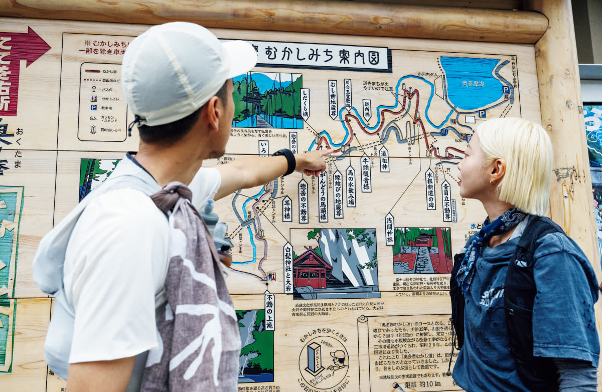 「奥多摩むかし道」のスタート看板前でルートをみている様子