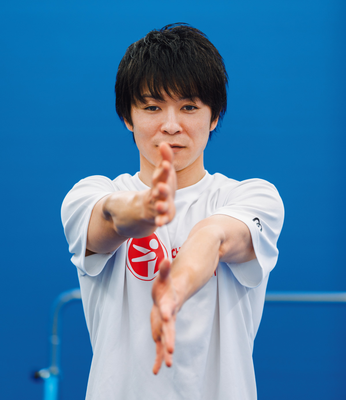 両手を顔の前で上下に並べるおなじみのポーズをとる内村航平さん