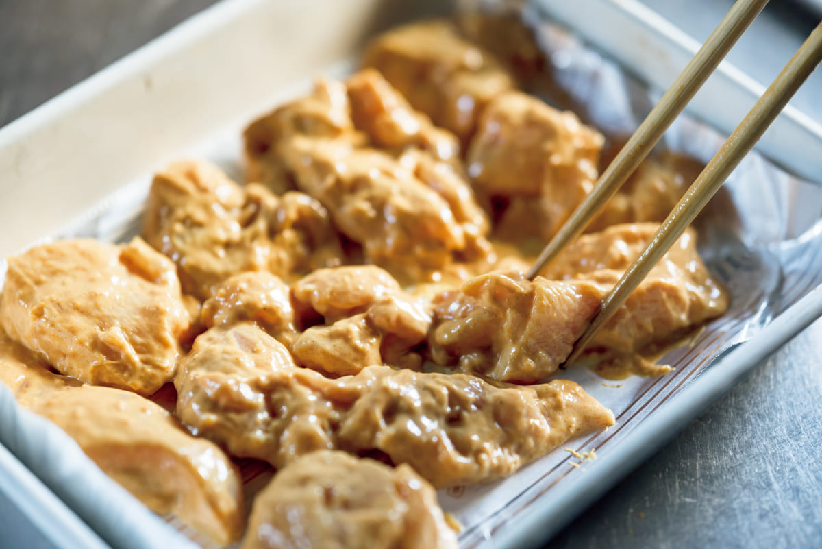 バッドにつけた鶏肉を並べている様子