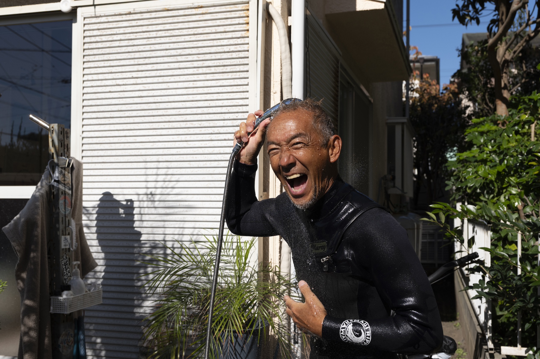 自宅前でシャワーを浴びる勝倉直道さん